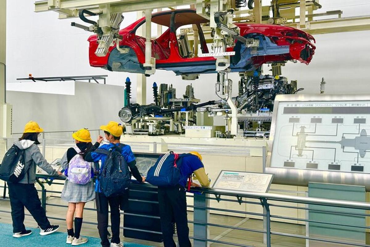 a group of people in a factory looking at a machine