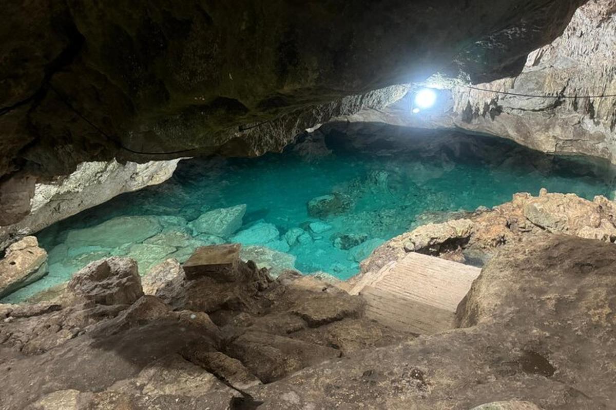 uma caverna com uma pessoa em uma luz na água