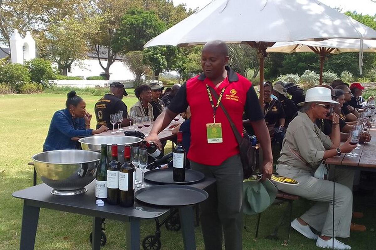 a man standing in front of a table with bottles of wine