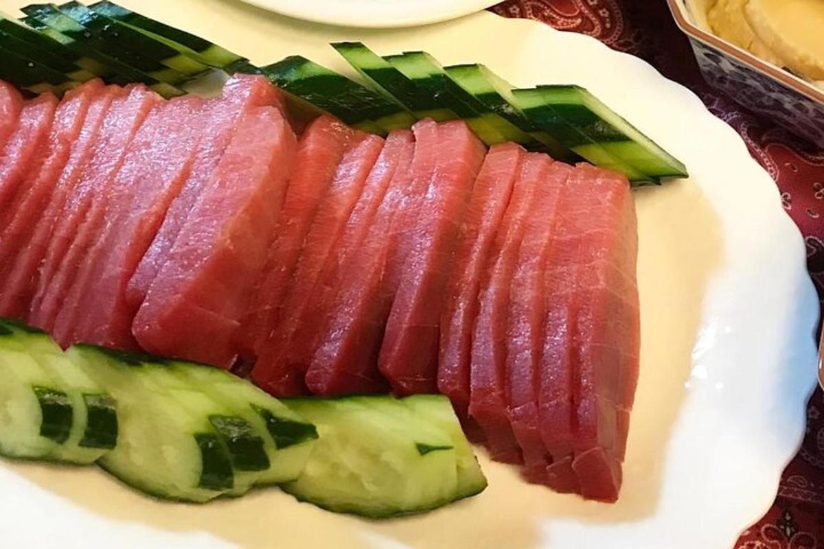 a plate of food with meat and cucumbers on it