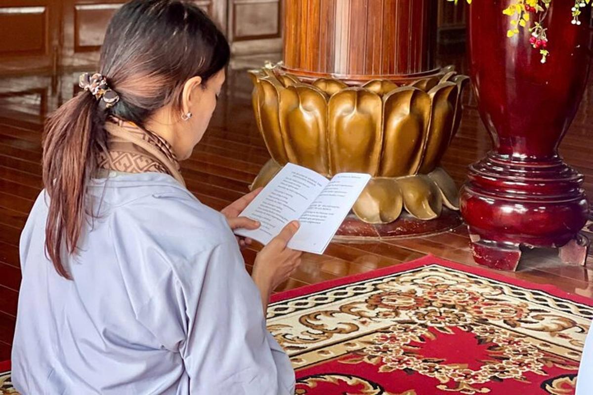 una donna che legge un libro davanti a un vaso