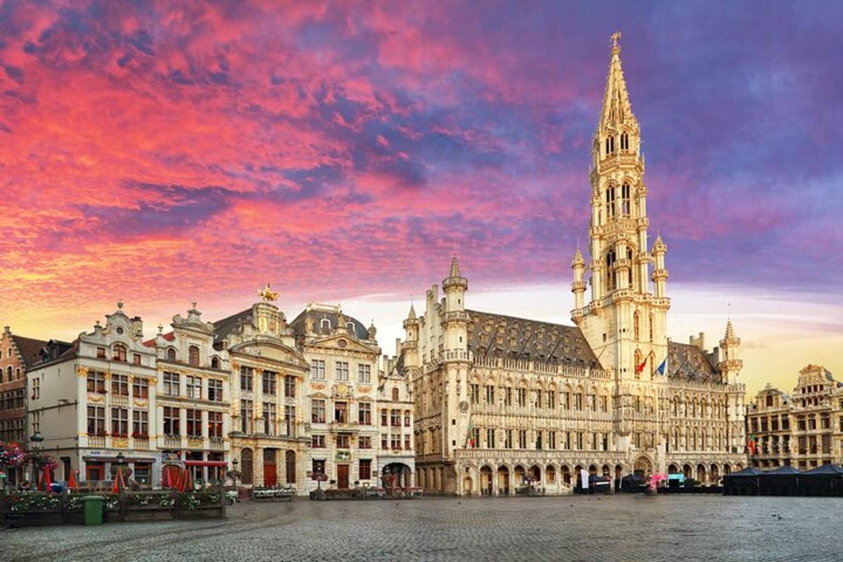 un grande edificio con una torre dell'orologio con un tramonto