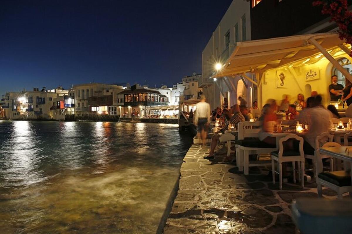 skupina lidí sedících v restauraci u vody