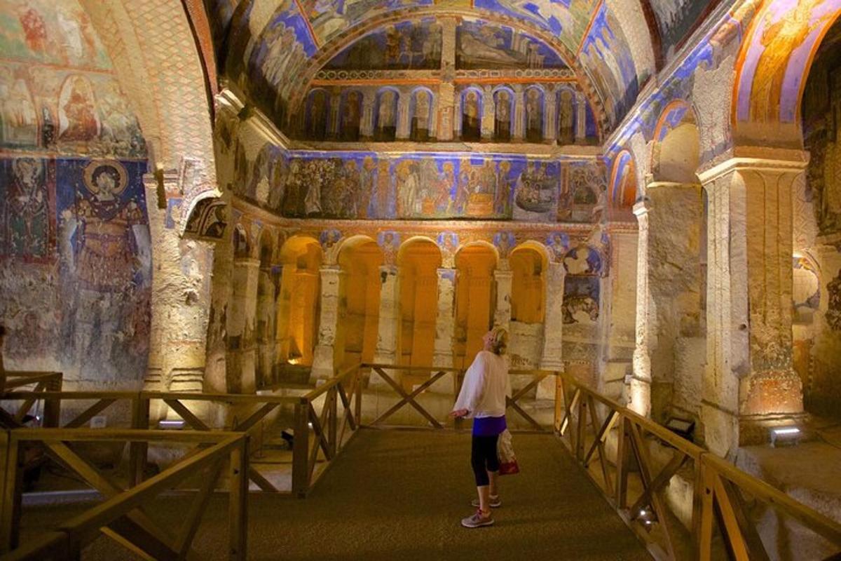 una donna in piedi in una stanza con dipinti alle pareti