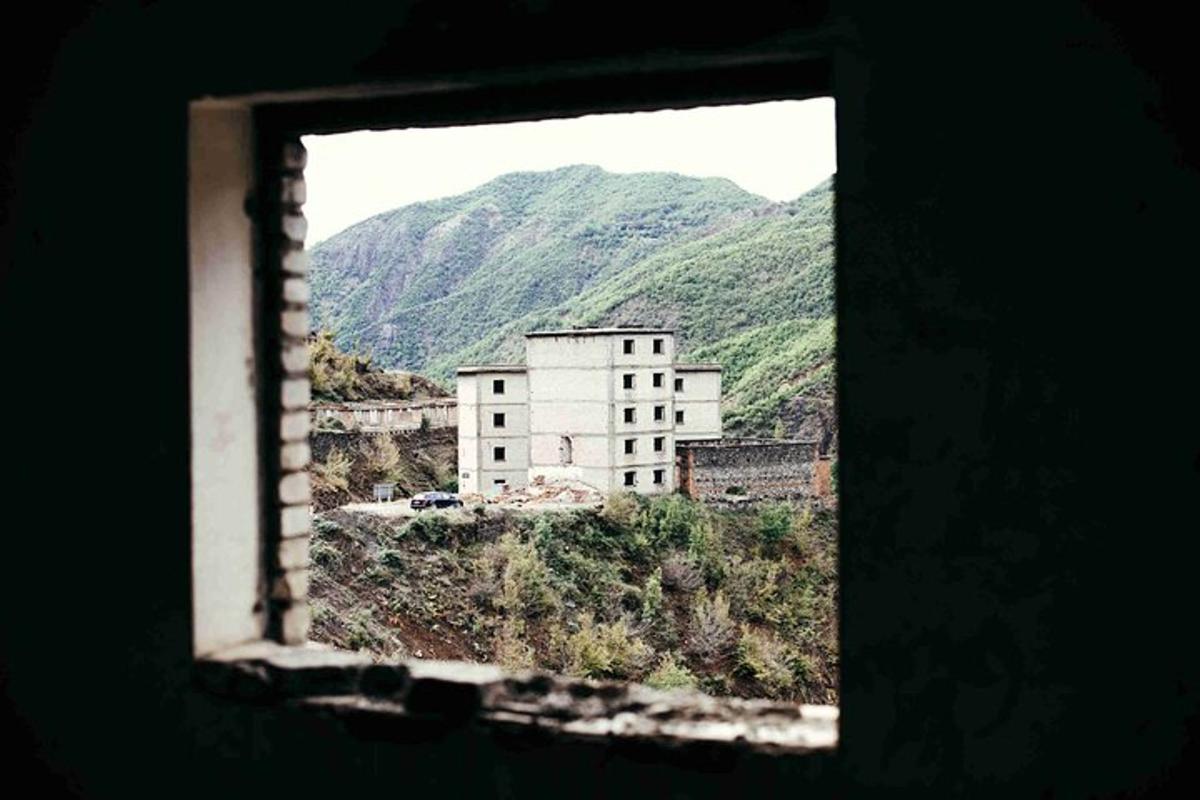 uma vista de um edifício de uma janela com montanhas