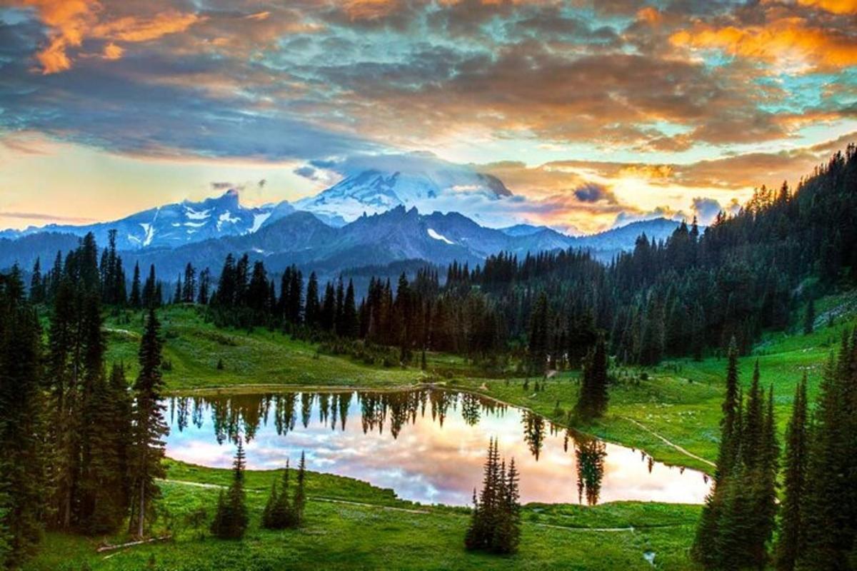 Una pintura de un lago en un campo con montañas.