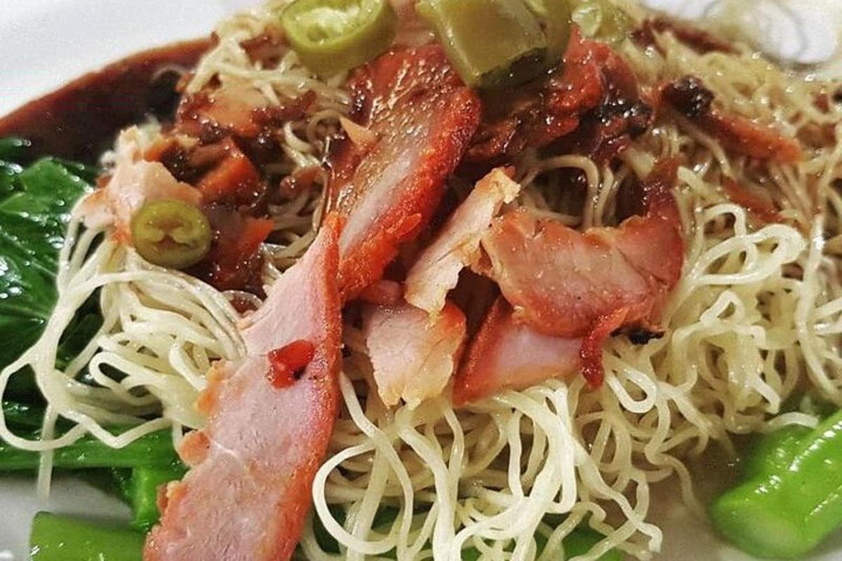 sepiring makanan dengan mie dan daging serta sayuran