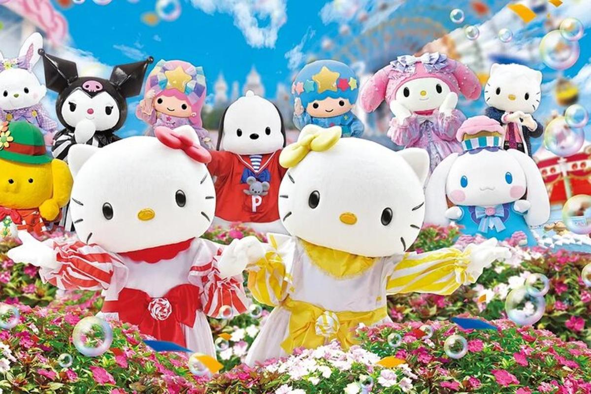 a group of hello kitty stuffed animals in a field of flowers