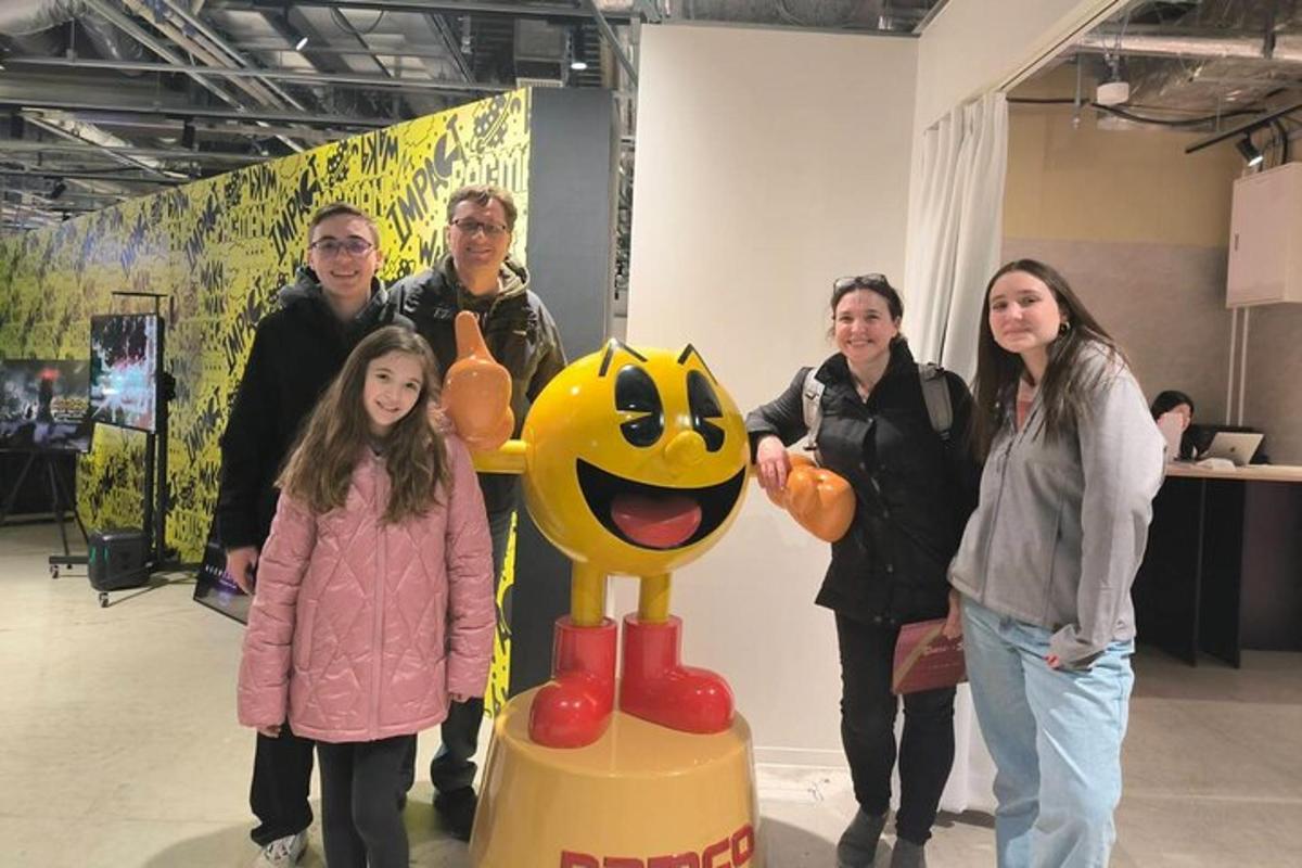 skupina lidí stojící vedle sochy smajlíka