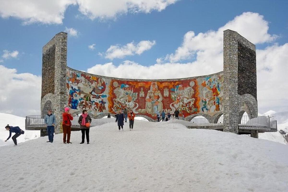 orang berjalan di salji di hadapan bangunan dengan mural