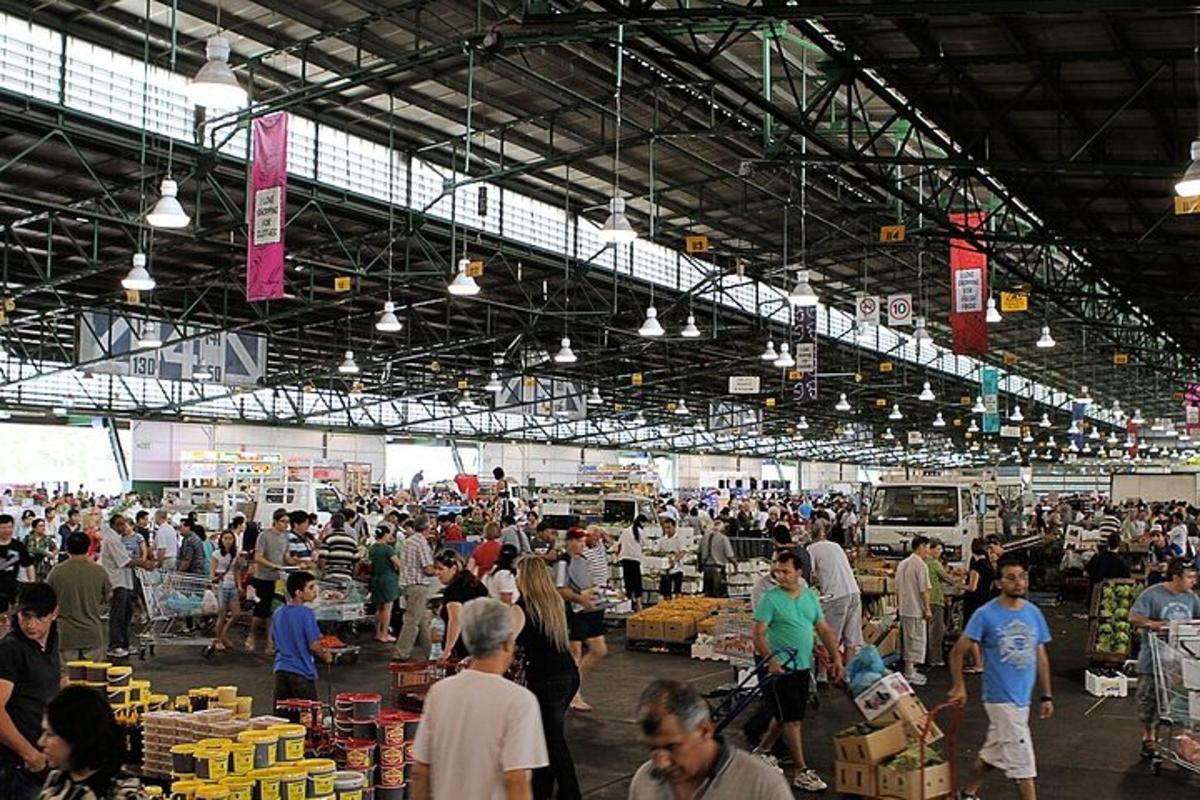 a crowd of people walking around a market
