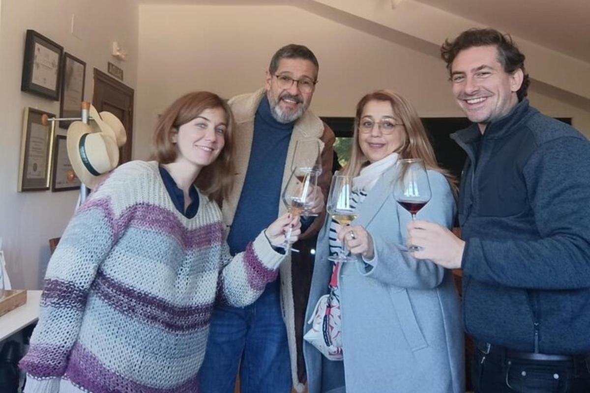 un grup de oameni care pozează pentru o fotografie cu pahare de vin