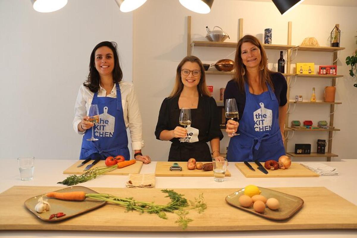 three women standing in a kitchen holding wine glasses