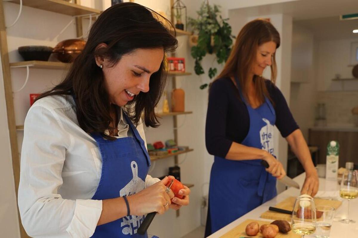 two women standing in a kitchen preparing food