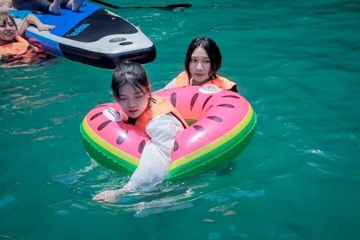 a boy and a girl in the water in a raft