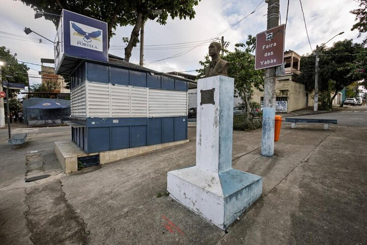 uma placa de rua e uma estátua na lateral de uma rua