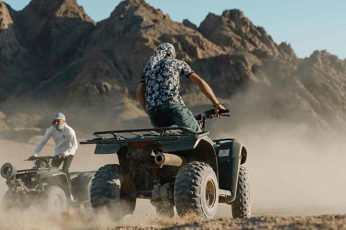 doi bărbați care călătoresc pe ATV-uri în deșert