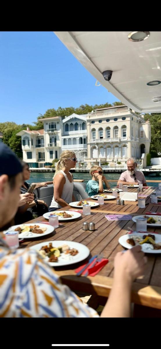 un gruppo di persone sedute a un tavolo che mangiano cibo