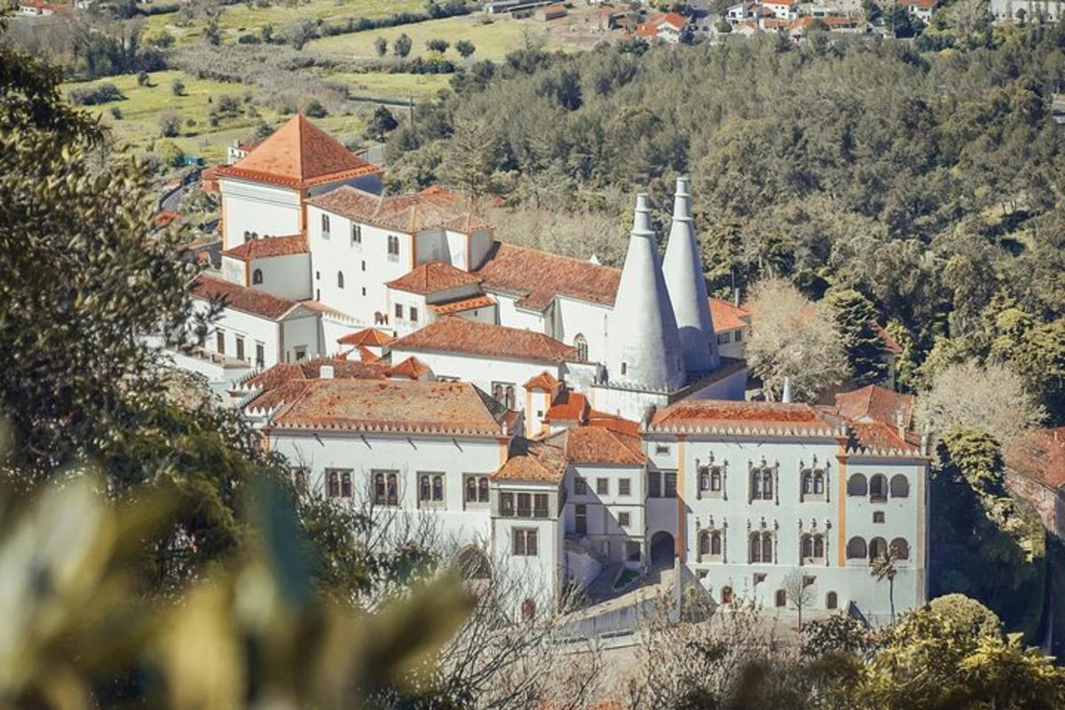 a large white building with a church on a hill