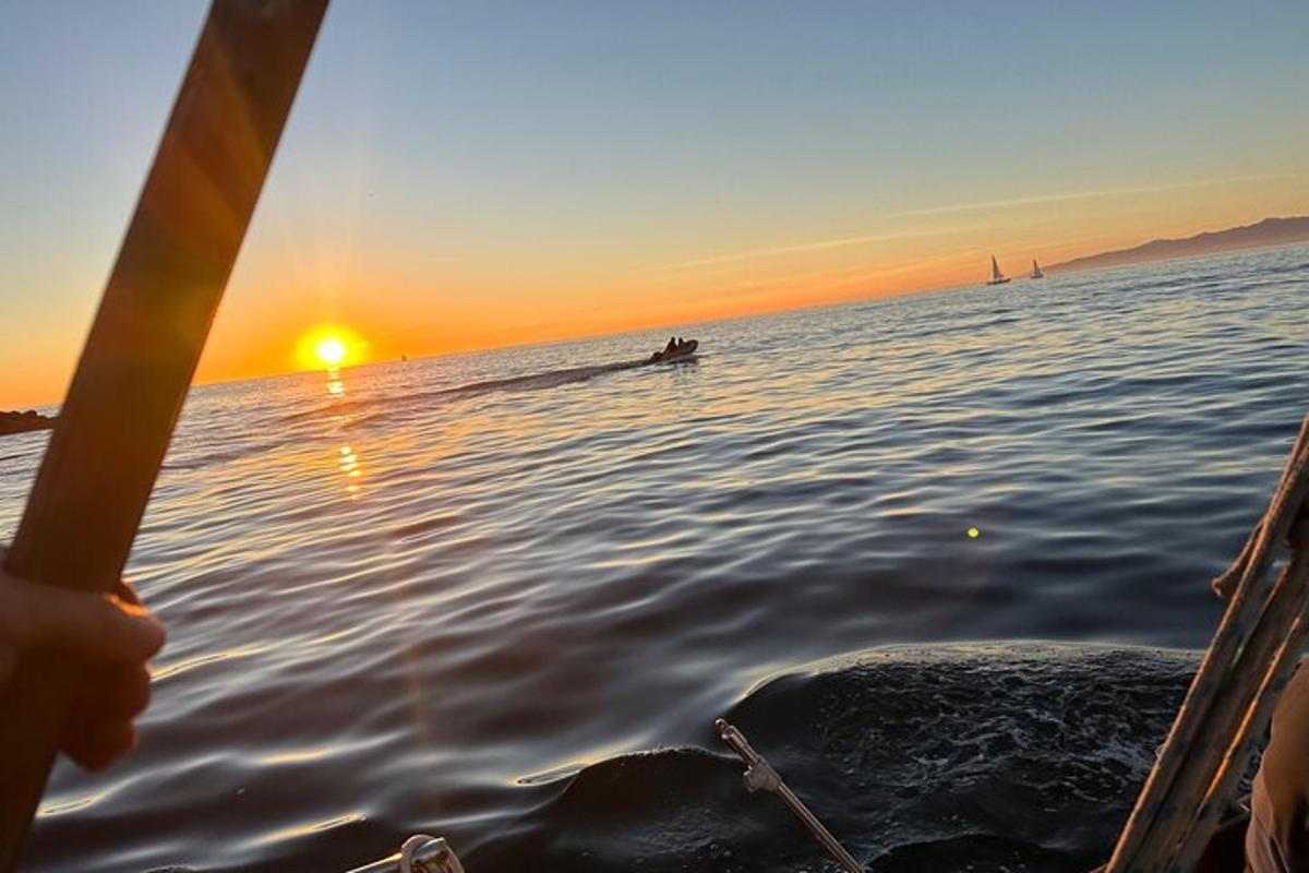 a person is rowing a boat in the water at sunset