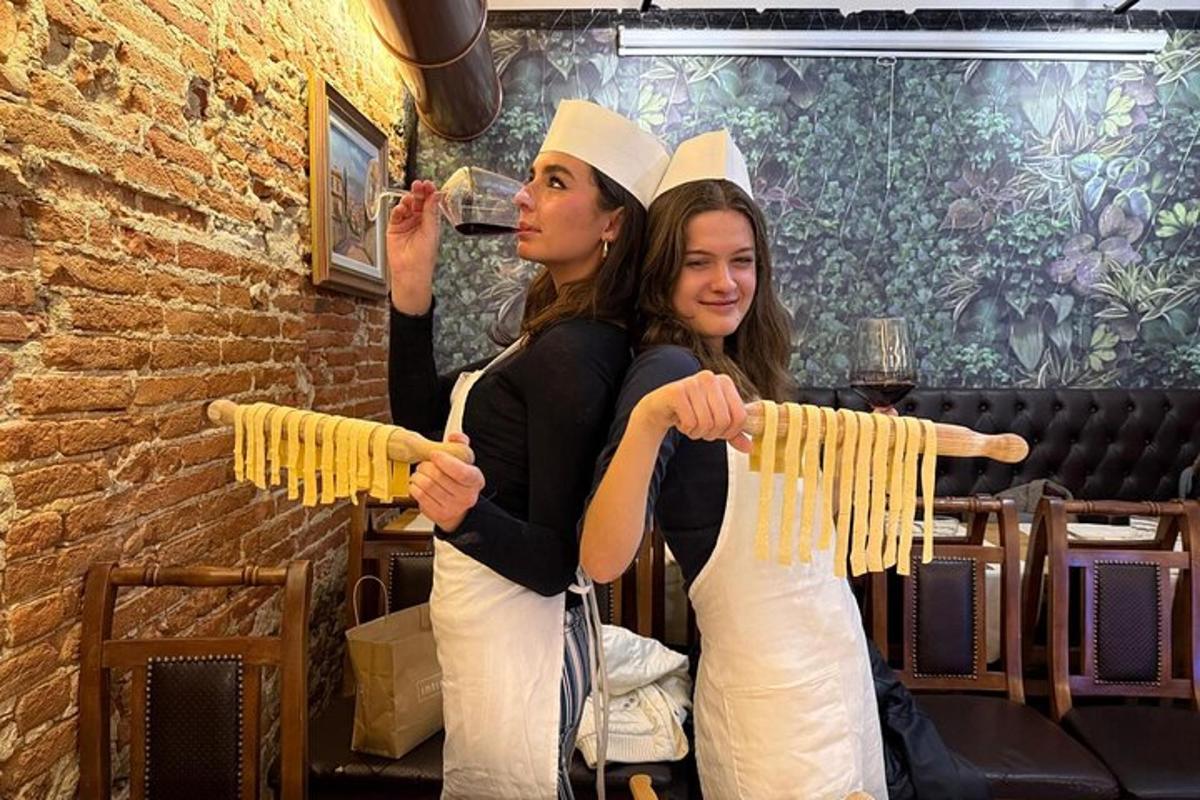 Dos mujeres paradas una al lado de la otra sosteniendo un montón de pasta