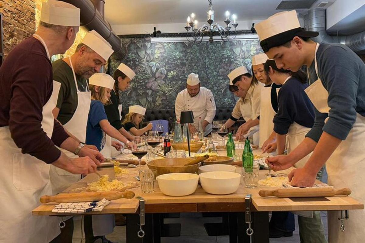 Un grupo de chefs de pie alrededor de una mesa preparando comida.