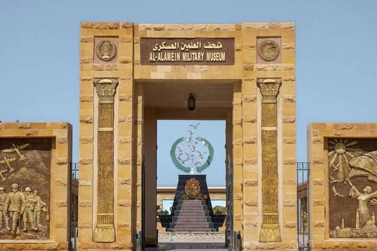 un ingresso di un edificio con un monumento sullo sfondo