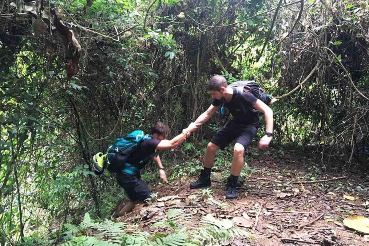 two people walking on a trail in the woods