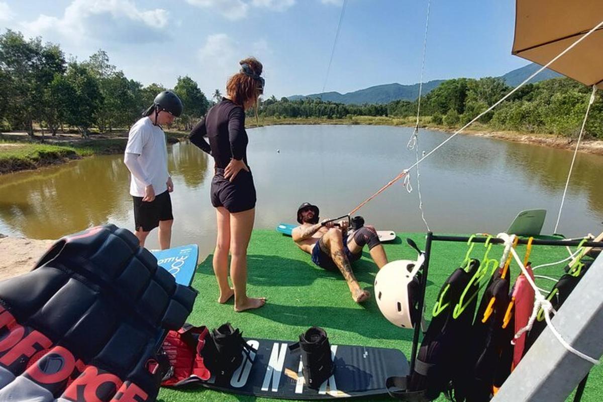 eine Gruppe von Menschen steht um einen Mann auf einem Floß im Wasser herum
