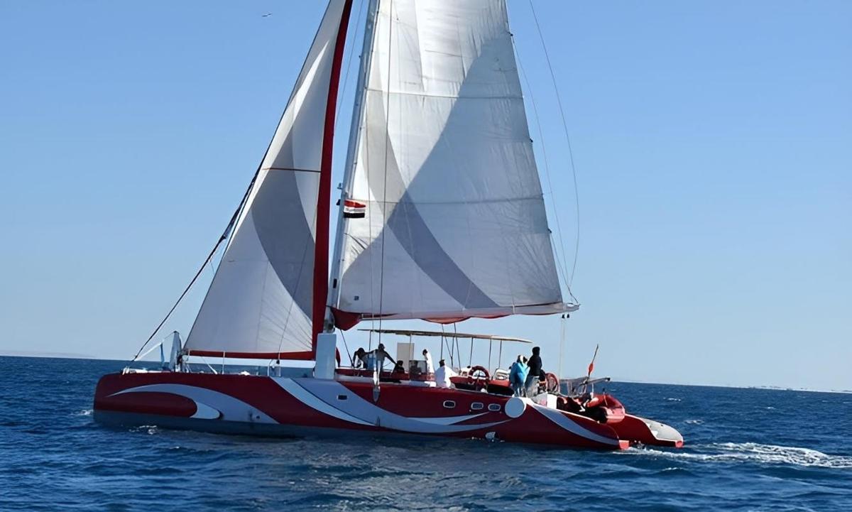 a red and white sail boat in the water