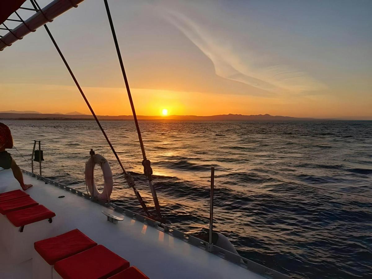 a man on a boat in the ocean at sunset