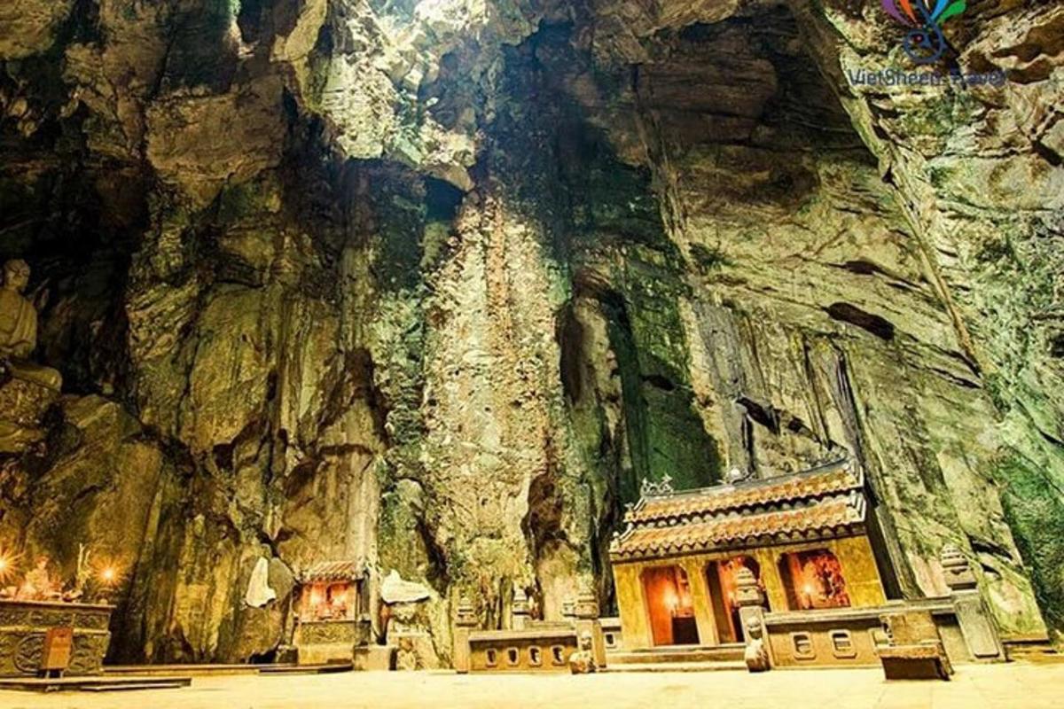 một hang động có tòa nhà ở phía trước một ngọn núi