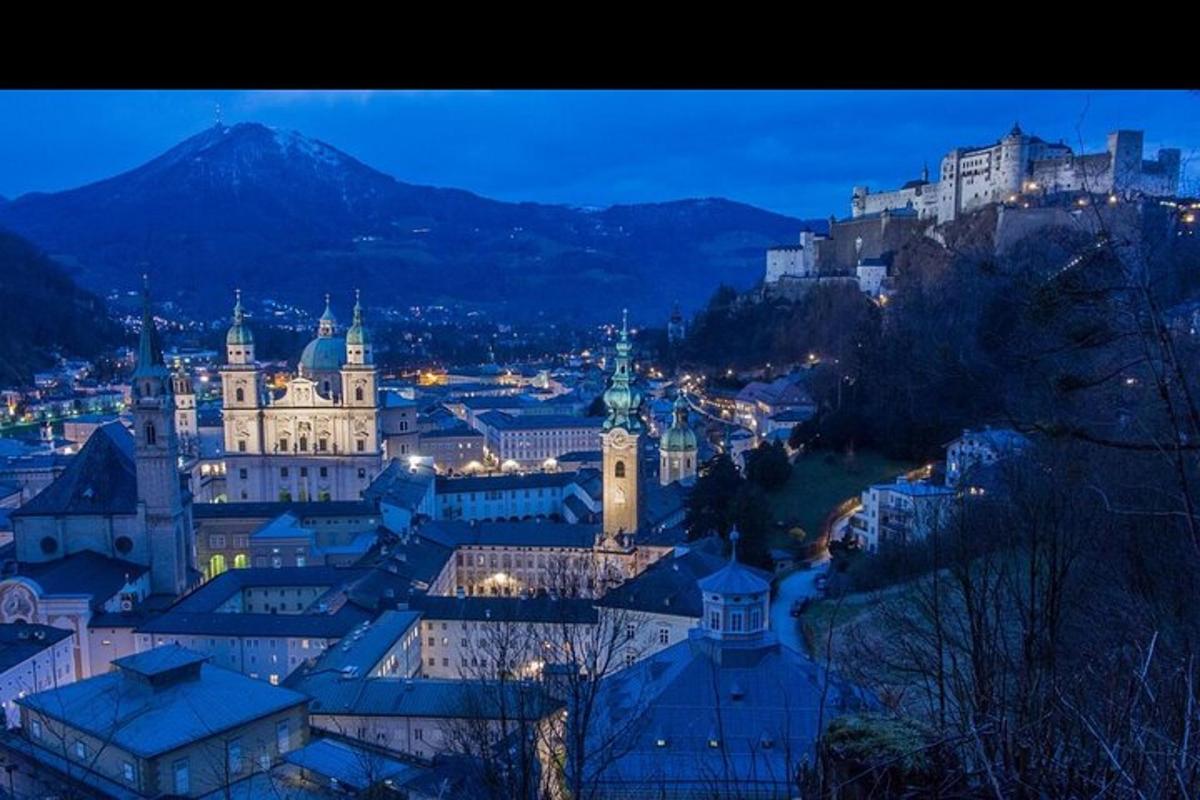 uma vista de uma cidade à noite com uma montanha