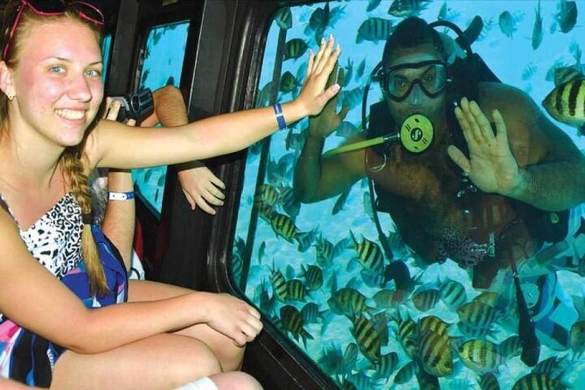 eine Frau sitzt neben einem Taucher in einem Aquarium