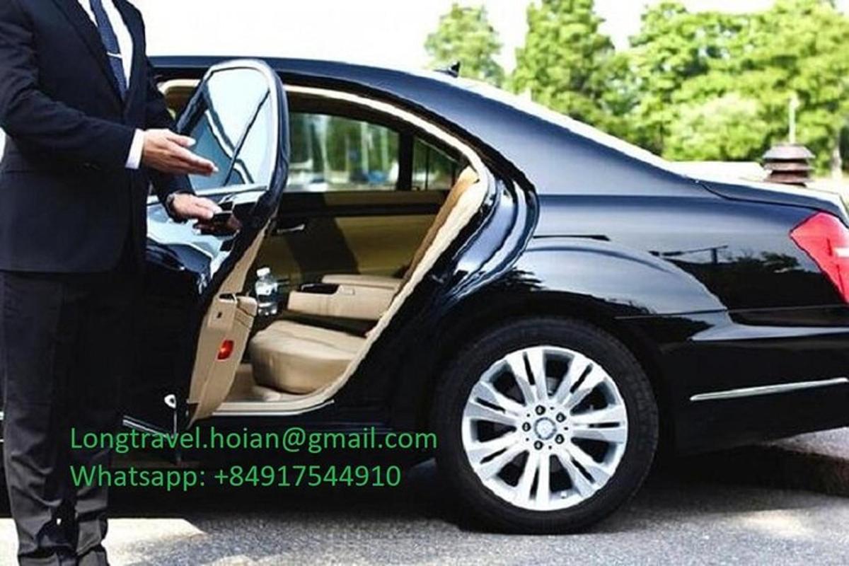 một người đàn ông đang mở cửa một chiếc xe ô tô màu đen