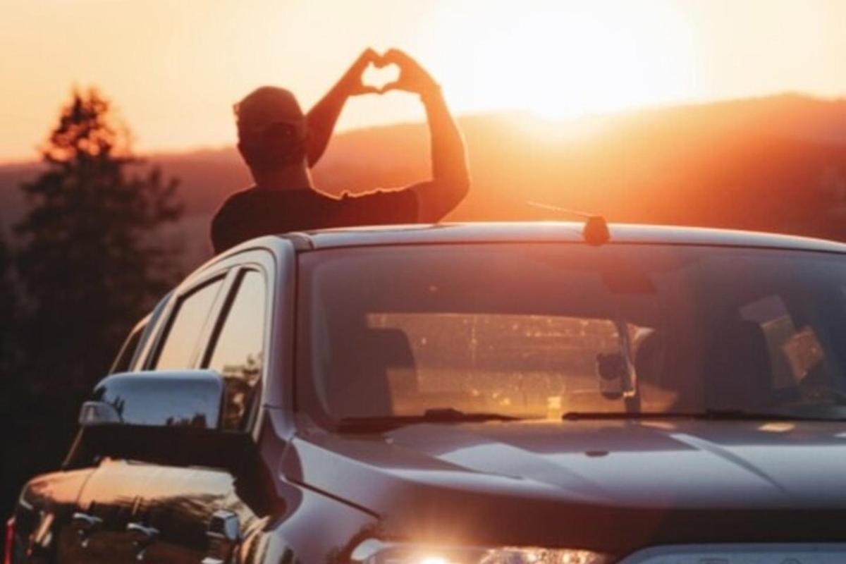 auto katusel istuv inimene teeb südamekujulist žesti