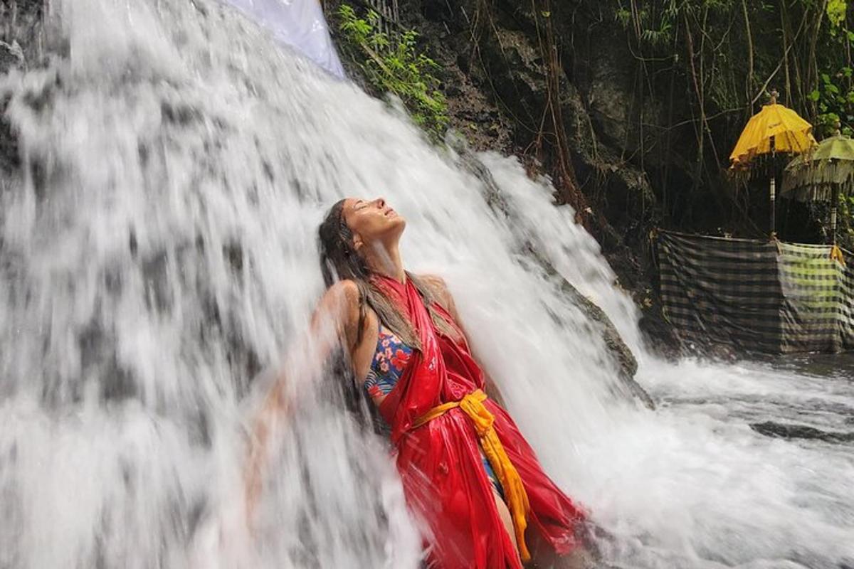 una donna in un vestito rosso in piedi davanti a una cascata
