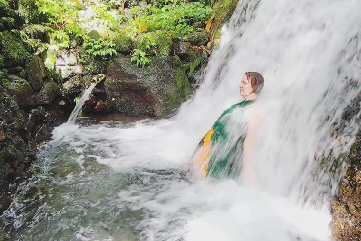 um homem parado em frente a uma cachoeira