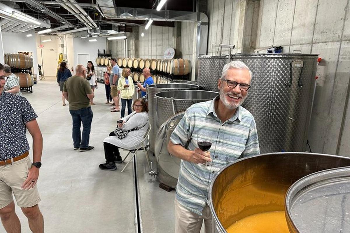 a man standing in a room with a glass of wine