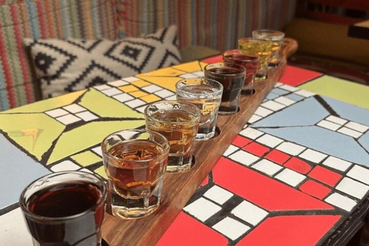 sebuah meja kayu dengan banyak gelas alkohol di atasnya