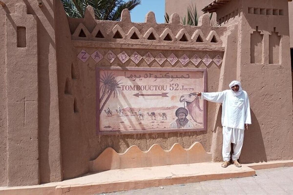 a man standing on a sidewalk next to a wall