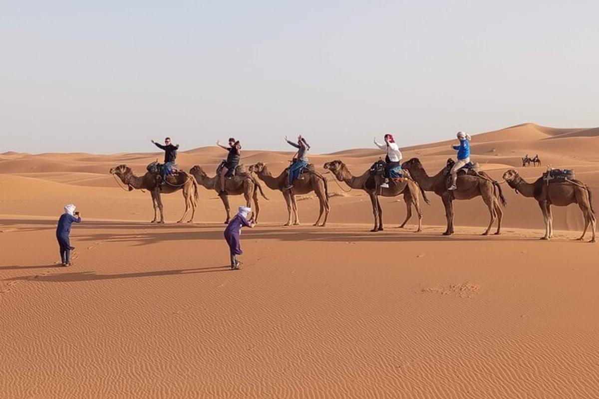 a group of people riding on camels in the desert