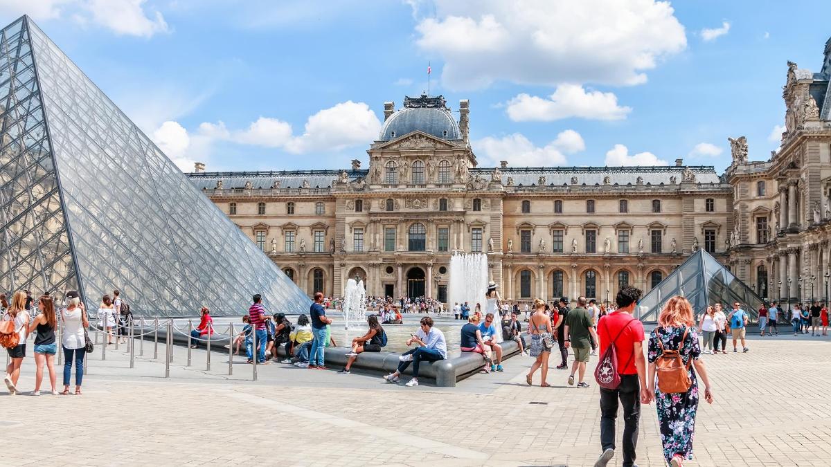 um grupo de pessoas em pé em frente a um grande edifício