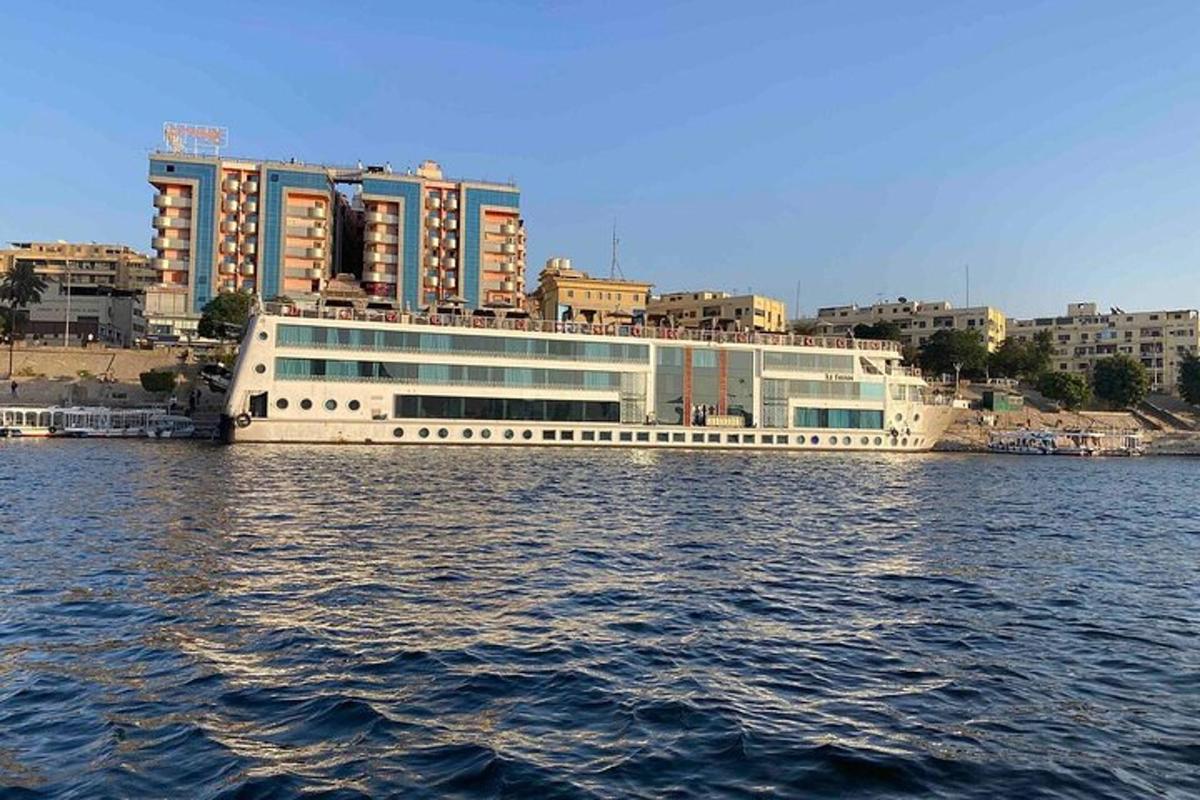 una nave da crociera in acqua con edifici sullo sfondo
