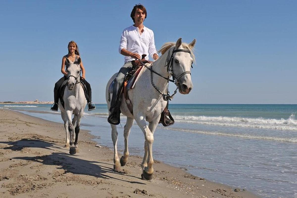 zwei Personen reiten am Strand