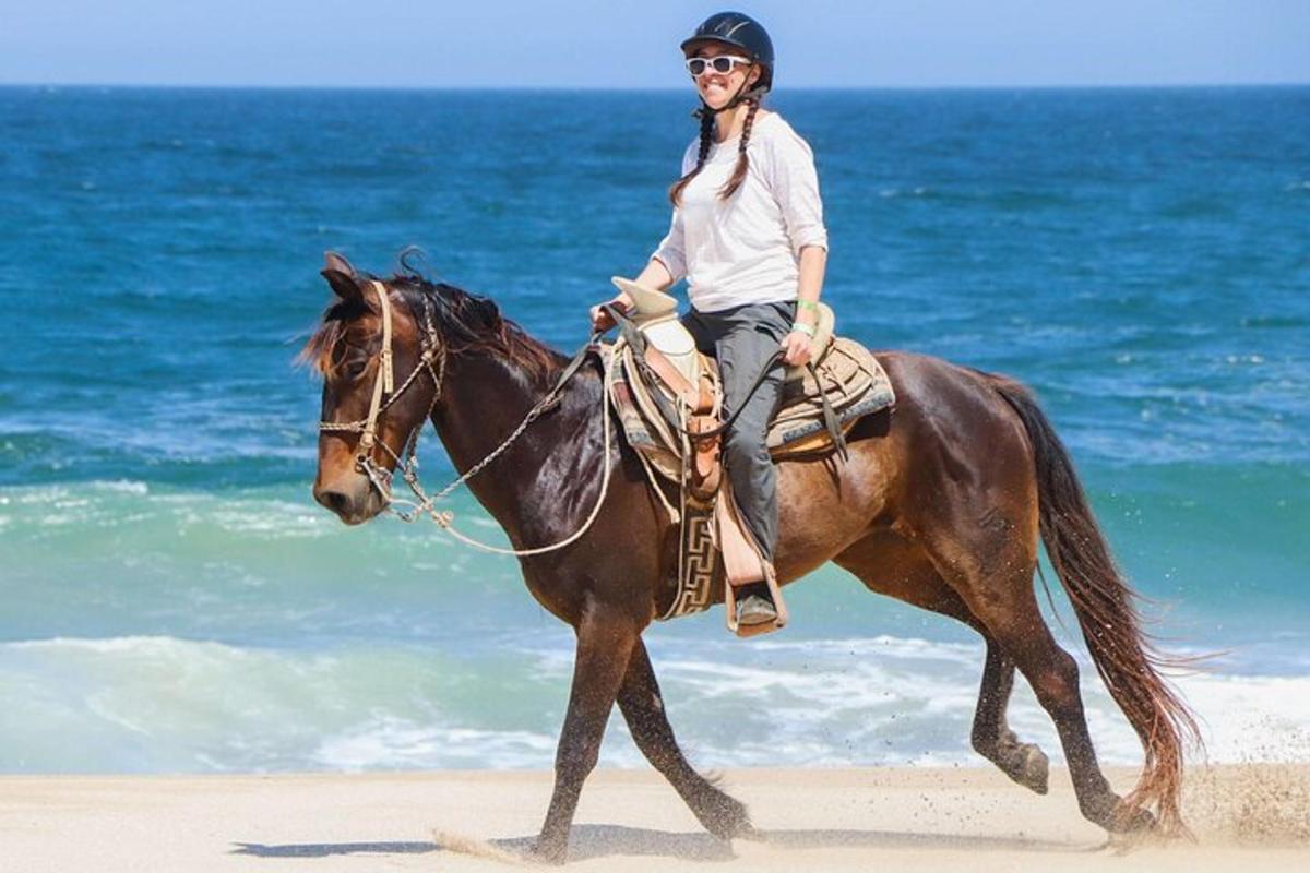 uma mulher cavalgando na praia