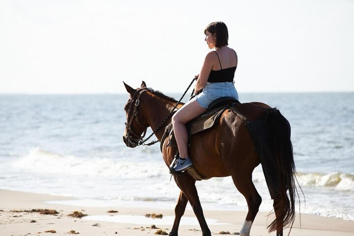 eine Frau, die am Strand reitet