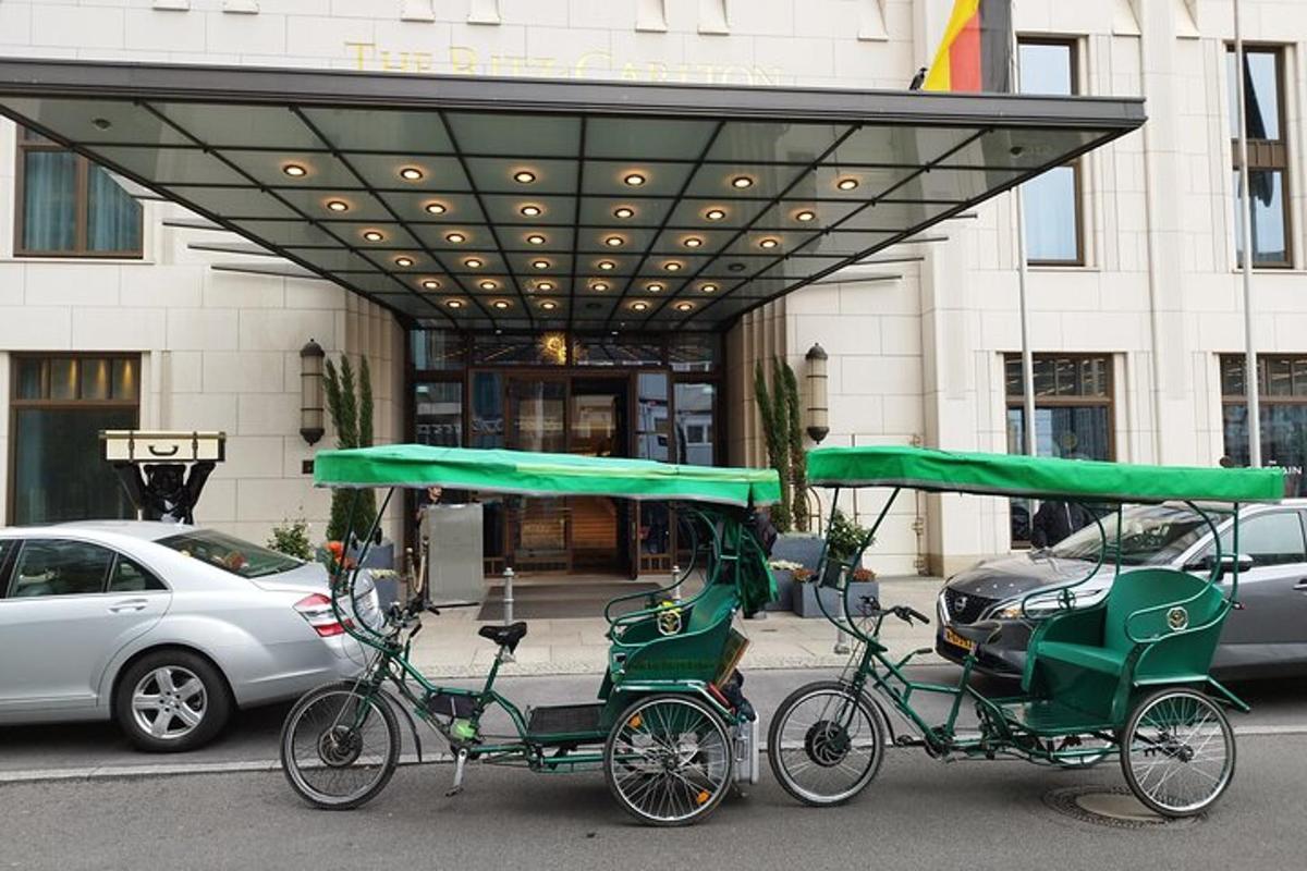 two green rickshaws parked in front of a building