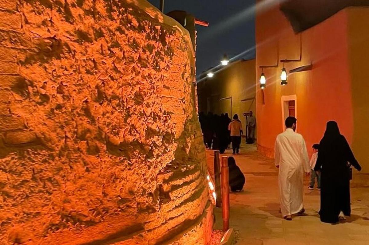 Un grupo de personas caminando por una calle de noche