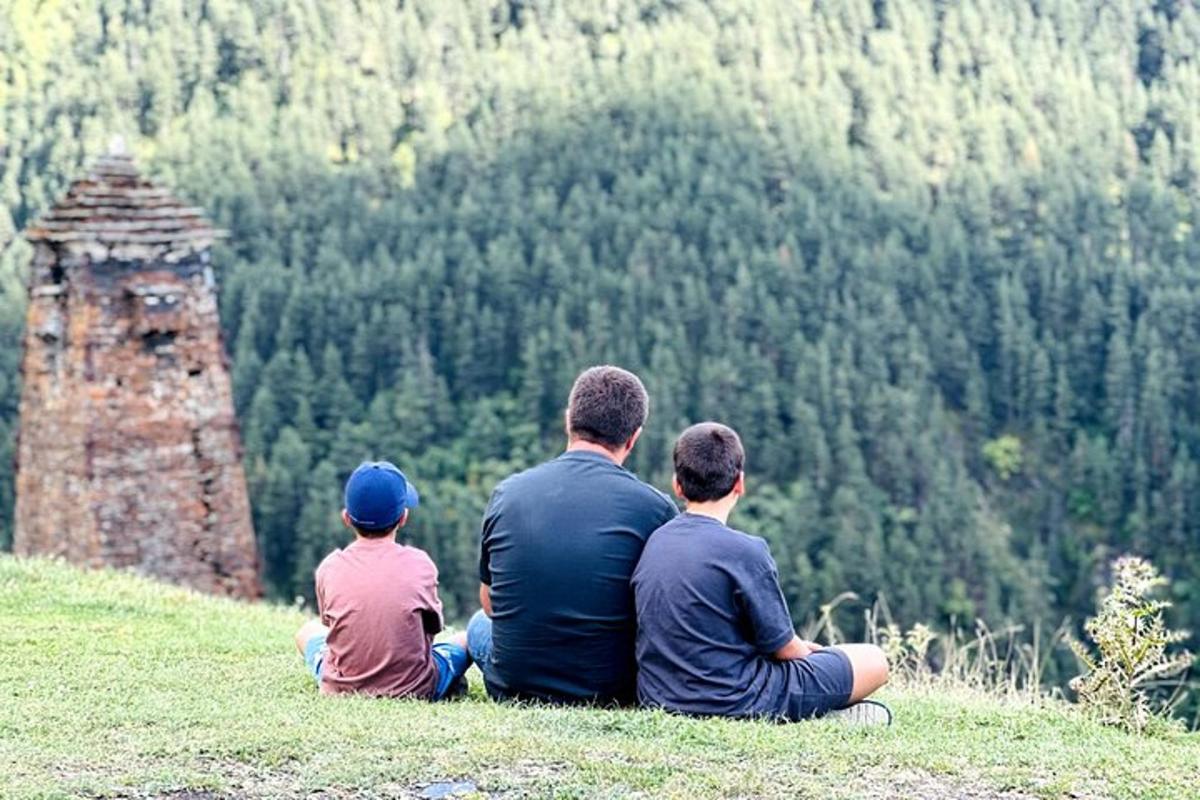 un gruppo di tre persone sedute in cima a una collina